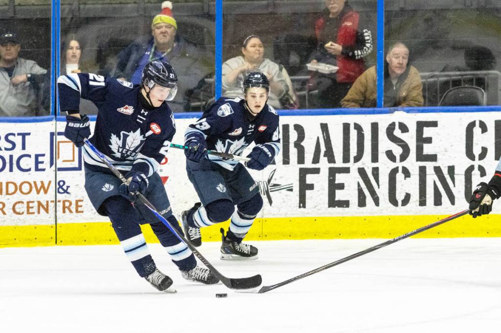 Penticton Vees forward Ryden Evers (21) skates with the puck past a Portland Winterhawks forward on Saturday, Jan. 31, 2026, at the South Okanagan Events Centre. Also seen is Jacob Kvasnicka (83), the Vees&rsquo; leading scorer thus far in 2025-26. (Photo by Cherie Morgan)